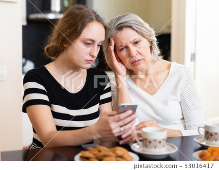Upset women using smartphone 53016417