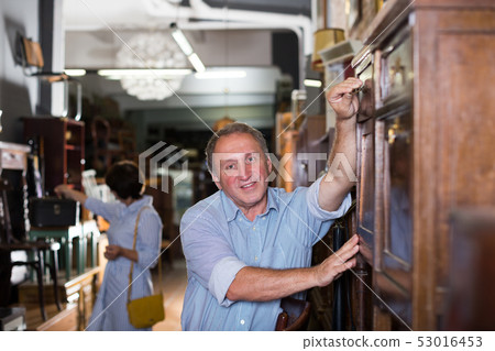 Mature couple is buying antique cupboard Mature couple is buying antique cupboard 53016453