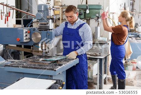 Male glazier working with glass on drilling machine 53016555