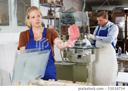 Female glazier working in glass factory 53016734
