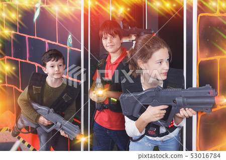 Laughing girl aiming laser gun at other players Laughing girl aiming laser gun at other players 53016784