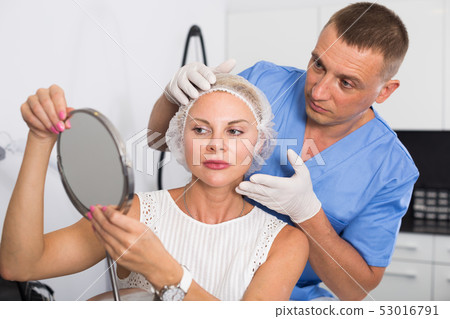 Man doctor is preparing female patient to procedure 53016791