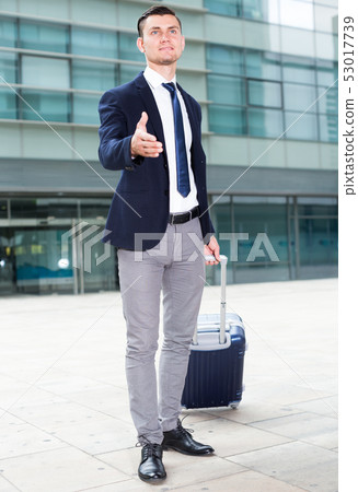 Man in suit with suitcase is meeting his partner 53017739
