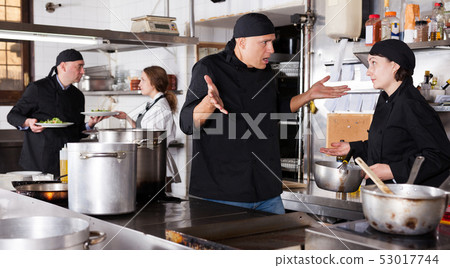 Chef male dissatisfied with the work of girl helper 53017744