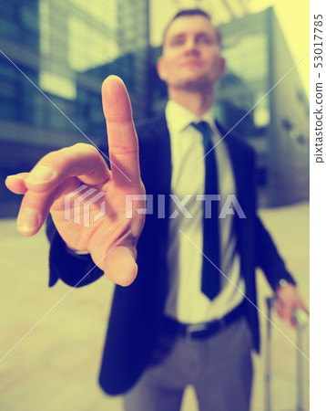 Office manager with suitcase asking companion to wait 53017785