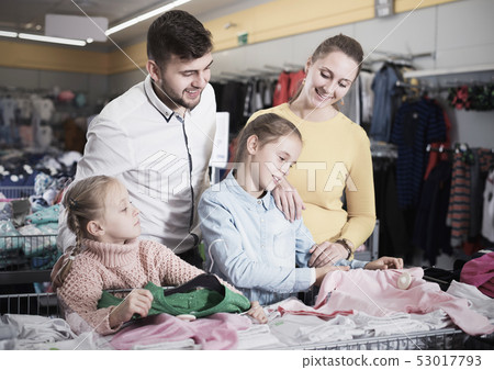 family with two girls choosing new clothes family with two girls choosing new clothes 53017793
