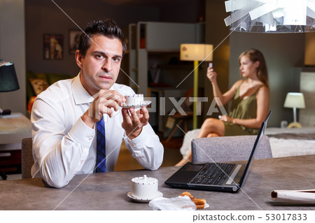Man drinking coffee and working with laptop Man drinking coffee and working with laptop 53017833