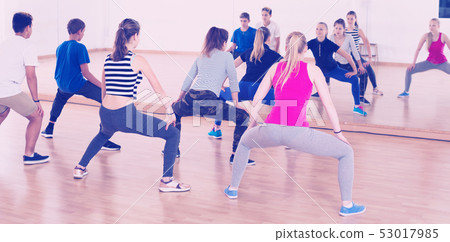 Teenagers stretching in dance hall Teenagers stretching in dance hall 53017985