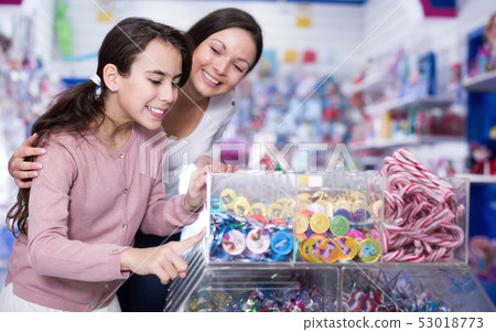 Woman with girl buying candies in the candy shop Woman with girl buying candies in the candy shop 53018773