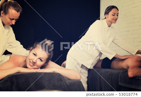 Portrait of couple getting relaxing massage in spa salon 53018774