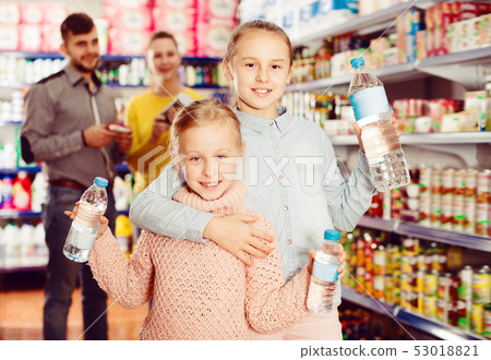 Two small nice sisters holding bottled water Two small nice sisters holding bottled water 53018821