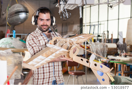 Male in aviator headphones with airplane models Male in aviator headphones with airplane models 53018977