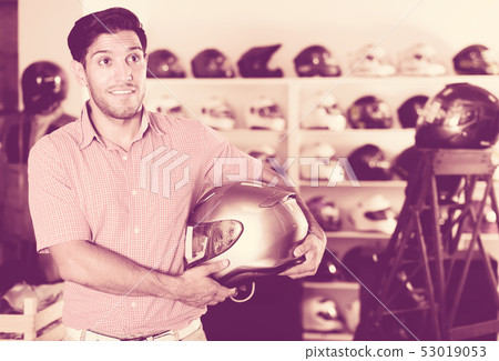 Man choosing moto helmet Man choosing moto helmet 53019053