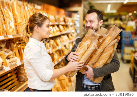 Couple is choosing bakery in bread department in the supermarket Couple is choosing bakery in bread department in the supermarket 53019086