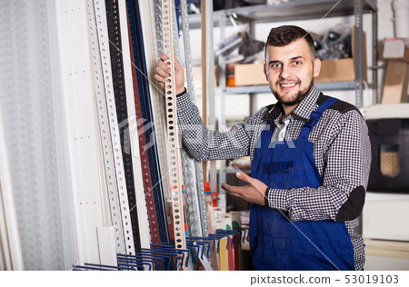 PVC industry worker in coverall with window and door profiles PVC industry worker in coverall with window and door profiles 53019103