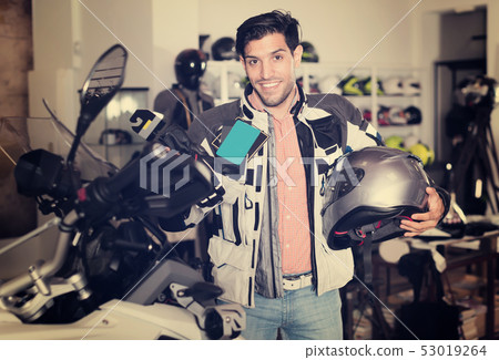 Young man is choosing new gloves Young man is choosing new gloves 53019264