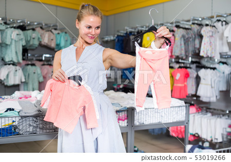 Customer woman is choosing clothes for daughter Customer woman is choosing clothes for daughter 53019266