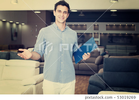 Man showing prices for sofas Man showing prices for sofas 53019269