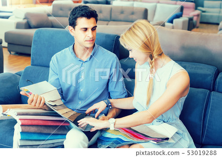 Happy man and wife choosing colors for new sofa Happy man and wife choosing colors for new sofa 53019288