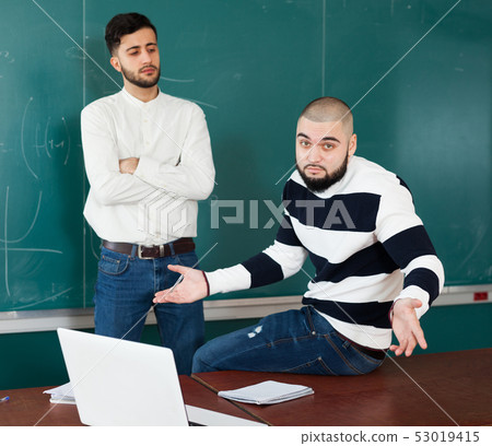 Quarrel between two young male students 53019415