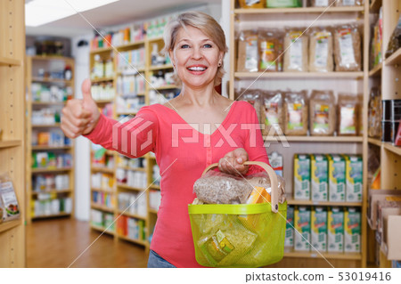 Mature female customer demonstrating healthy food 53019416