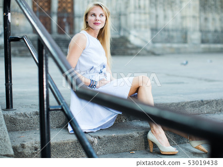 portrait of woman sitting on steps 53019438