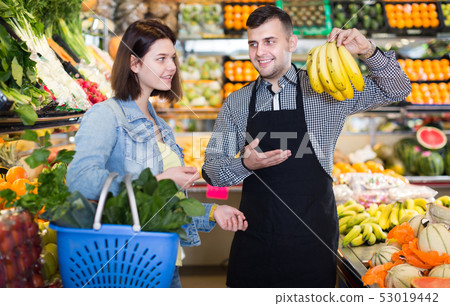 Male seller assisting in buying Male seller assisting in buying 53019442