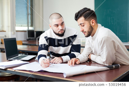 Guys working on student project at desk Guys working on student project at desk 53019456