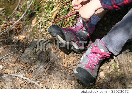 A woman repairing a string on a mountain path A woman repairing a string on a mountain path 53023072