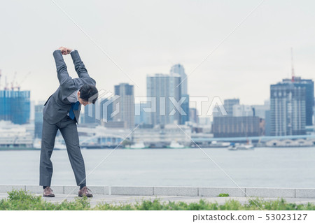 Stretching businessmen Stretching businessmen 53023127