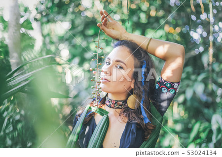Young beautiful sensual brunette girl on a tropical garden background in ethnic Indian boho style, Young beautiful sensual brunette girl on a tropical garden background in ethnic Indian boho style, 53024134