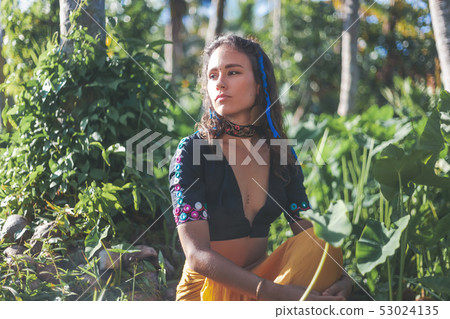 Young beautiful sensual brunette girl on a tropical garden background in ethnic Indian boho style, 53024135