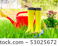 Yellow rubber boots, red watering can and tools 53025672