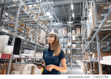 Wholesale warehouse. Beautiful young woman worker of store in shopping center. Girl looking for Wholesale warehouse. Beautiful young woman worker of store in shopping center. Girl looking for 53025794