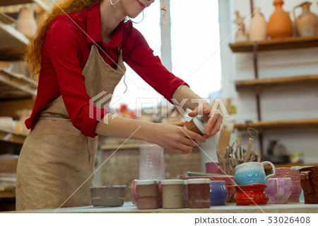 Pleasant long-haired girl in red shirt preparing paints 53026408