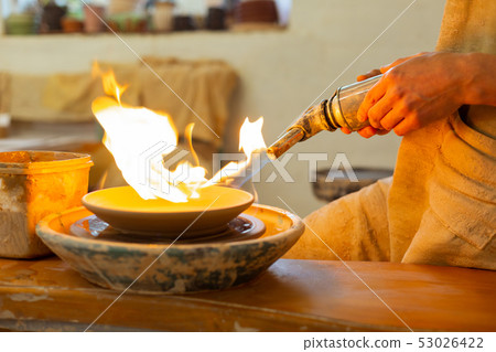 Strong calm man holding special burning tool for baking Strong calm man holding special burning tool for baking 53026422