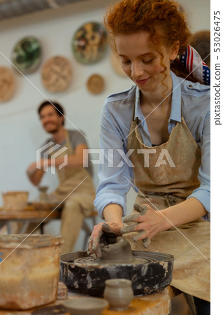Positive long-haired curly girl in light blue shirt studying new technique Positive long-haired curly girl in light blue shirt studying new technique 53026475