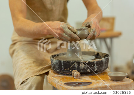 Man with dirty hands wearing protective apron while working 53026556
