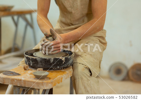 Experienced clay master intensely pressing on moving clay figure Experienced clay master intensely pressing on moving clay figure 53026582
