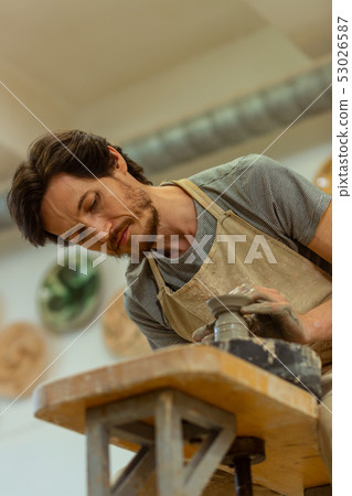 Diligent dark-haired qualified master accurately creating pot 53026587