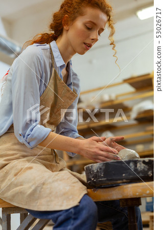 Focused young lady enjoying time spending in pottery workshop 53026717