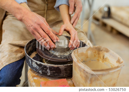 Romantic couple working together on pottery wheel 53026750