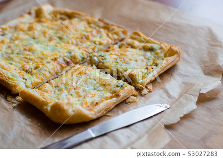 Deliciously simple cheese tart with green peas and eggs on parchment paper. Summer tart. Top view Deliciously simple cheese tart with green peas and eggs on parchment paper. Summer tart. Top view 53027283
