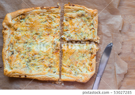 Deliciously simple cheese tart with green peas and eggs on parchment paper. Summer tart. Top view 53027285