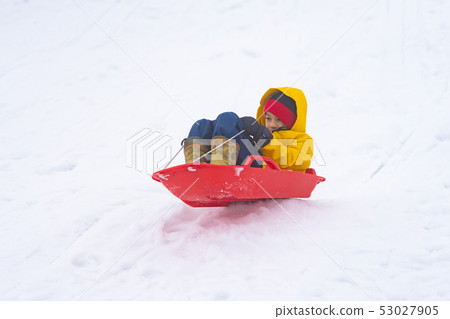 Little Japanese girl is sliding down the snow sled 53027905