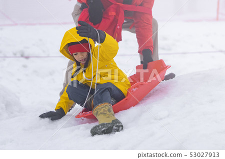 Father is helping her daughter to ride the snow Father is helping her daughter to ride the snow 53027913