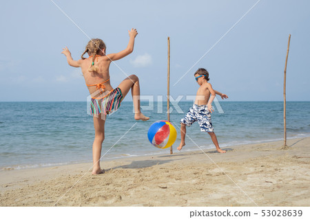 Two happy little children playing on the beach at Two happy little children playing on the beach at 53028639