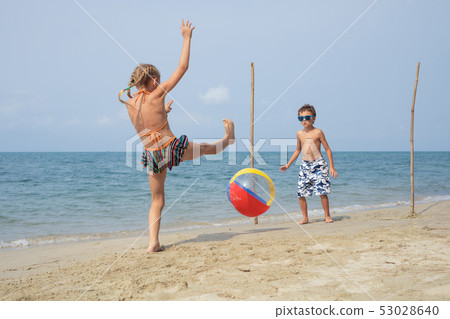Two happy little children playing on the beach at Two happy little children playing on the beach at 53028640