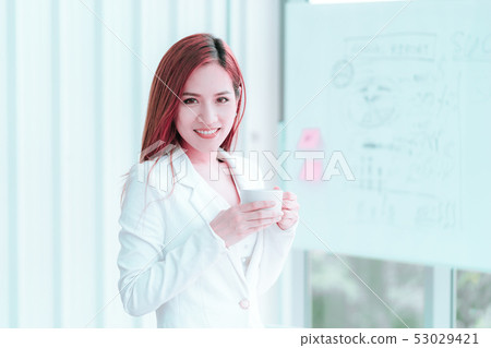 Young Asian woman in white is taking a break with Young Asian woman in white is taking a break with 53029421