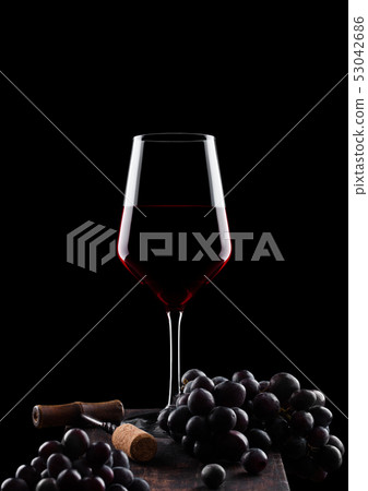 Glass of red wine with dark grapes and vintage 53042686